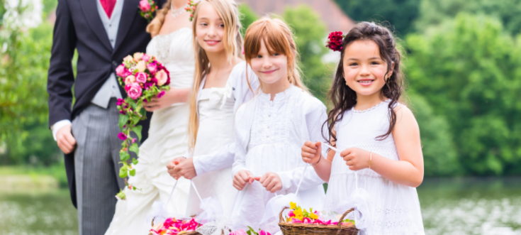 Blumenkinder streuen Blumen auf dem Weg des Brautpaares bei einer Hochzeit.