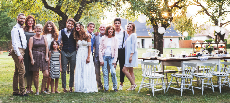 Hochzeitsgäste gratulieren dem Brautpaar beim Sektempfang nach der Trauung