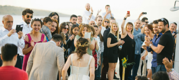 Brautpaar kommt aus dem Standesamt und wird von jubelnden Hochzeitsgästen empfangen