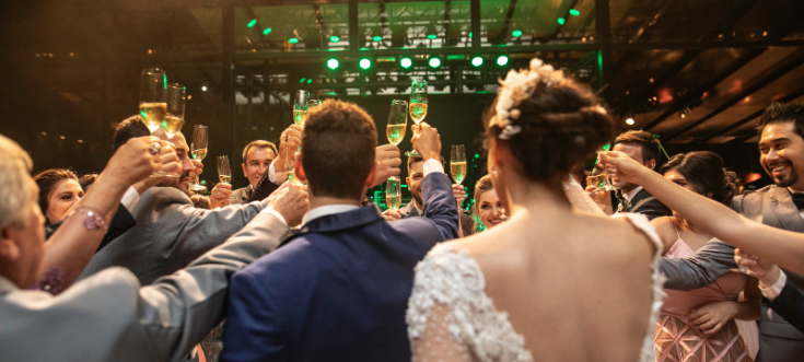 Brautpaar stößt beim Sektempfang gemeinsam mit den Hochzeitsgästen an